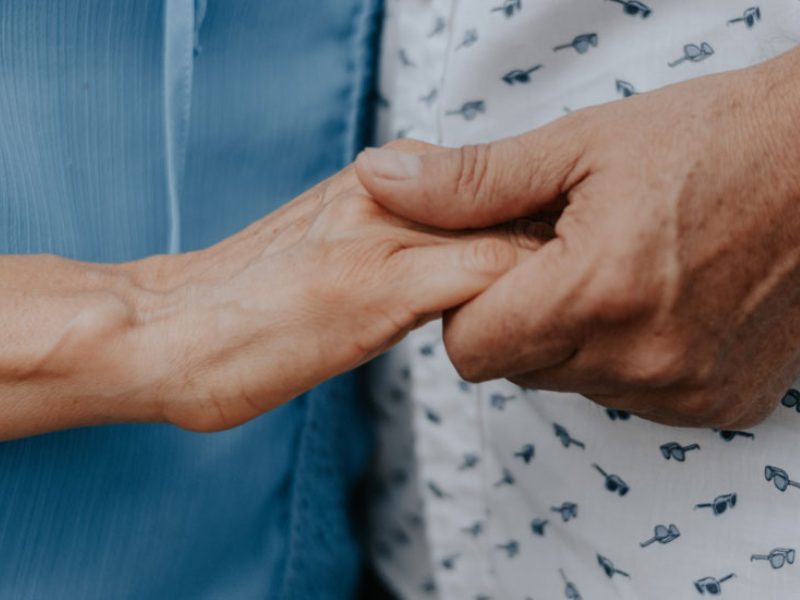 holding hands of two elderly people