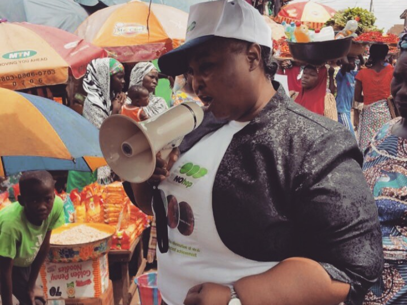 woman holding speaker for advocacy at a market